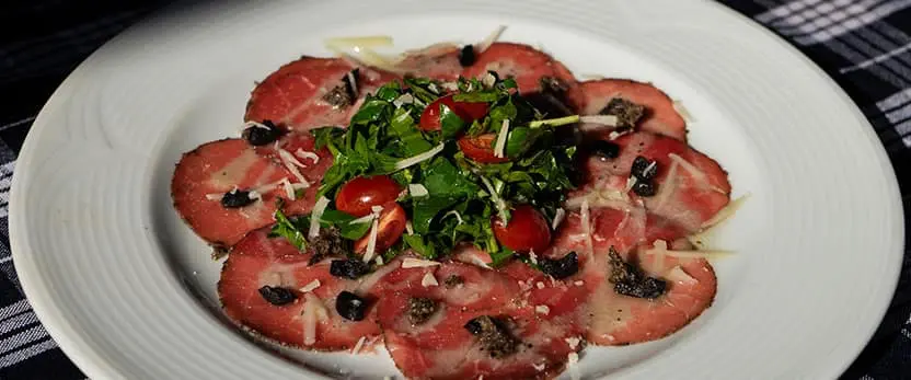 se muestra el platillo Carpaccio di manzo al limone giallo e tartufo